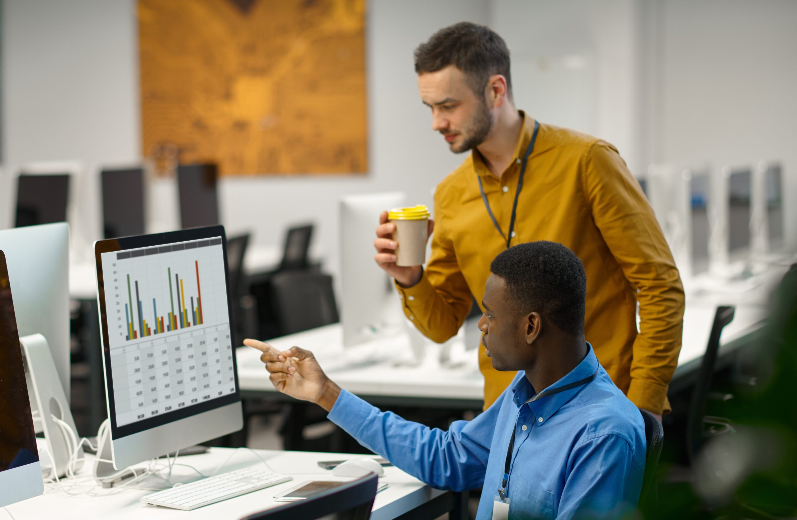 Two male managers works on computer in IT office Corso Digital Marketing